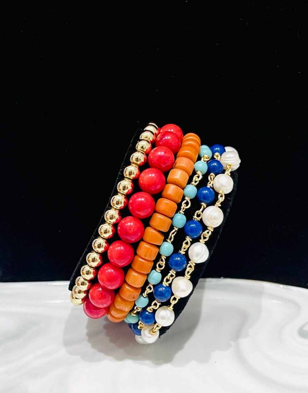 Corals, magnesites, mountain jade and high quality gold-bonded beads. Elastic and wire wrapped mix.